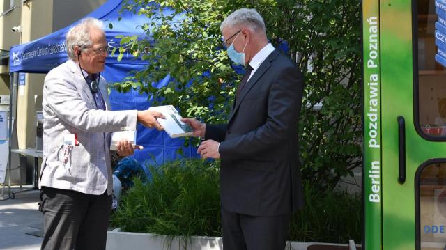 Heiner Klemp bei der Buchübergabe an Stadtpräsident Jacek Jaśkowiak vor der BiblioboXX